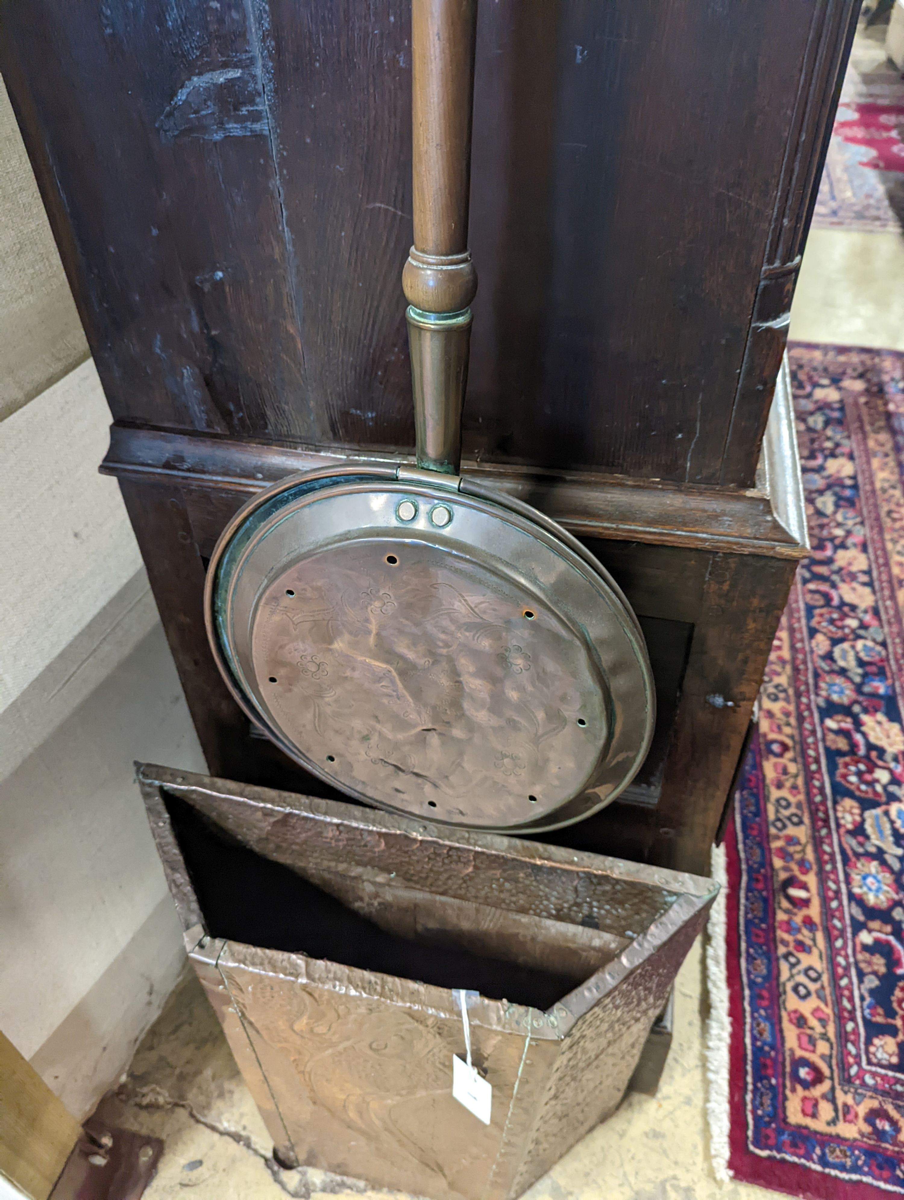 An early 20th century embossed copper stick stand, height 60cm, together with a Victorian copper warming pan